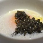 Huevo con caviar servido en vaso sobre un fondo de parmentier de patata