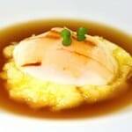 Huevo de caserío asado con caldo de garbanzos, patata rota y láminas de tocino ibérico